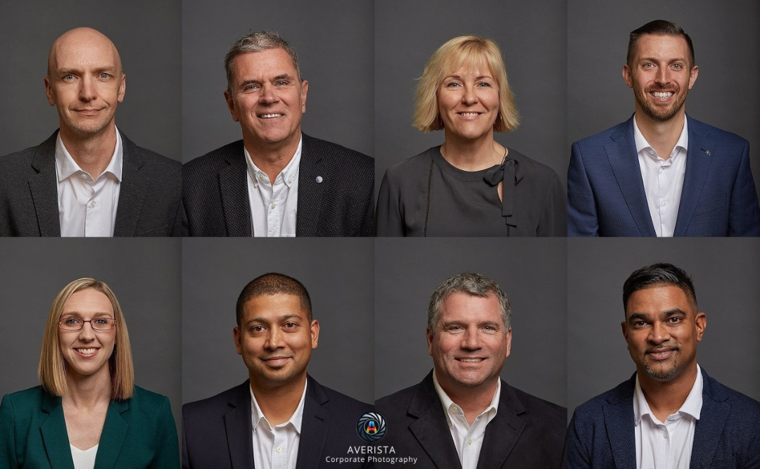 Diverse corporate team posing for a professional photo in a modern office setting.